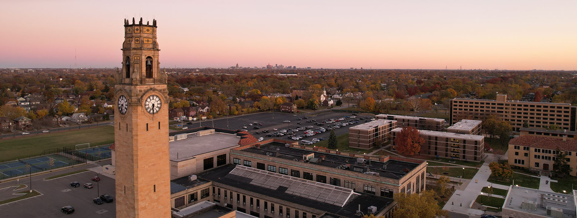 An aerial shot of Detroit Mercy's McNichols Campus, featuring the clocktower and downtown Detroit in the distance.