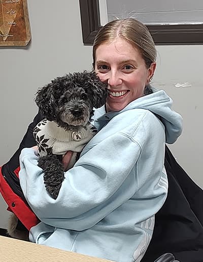 Image of a female student holding the poodle dog Bentley