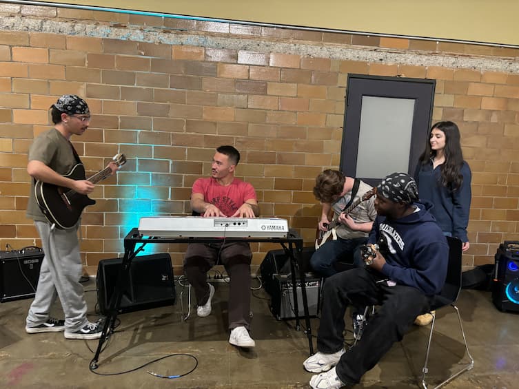 An image of four people with musical instruments in their hands.