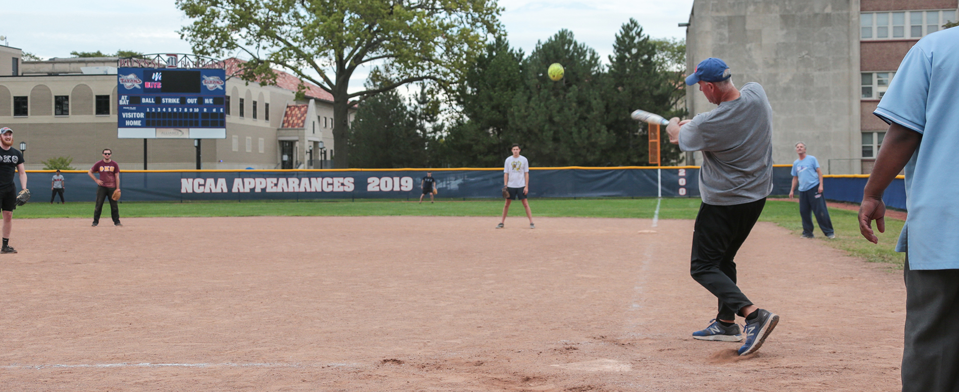 A ball is hit during the Homecoming softball tournament, held at Detroit Mercy’s Buysse Ballpark. A banner for NCAA Appearances 2019 is seen in the background on the outfield fence.