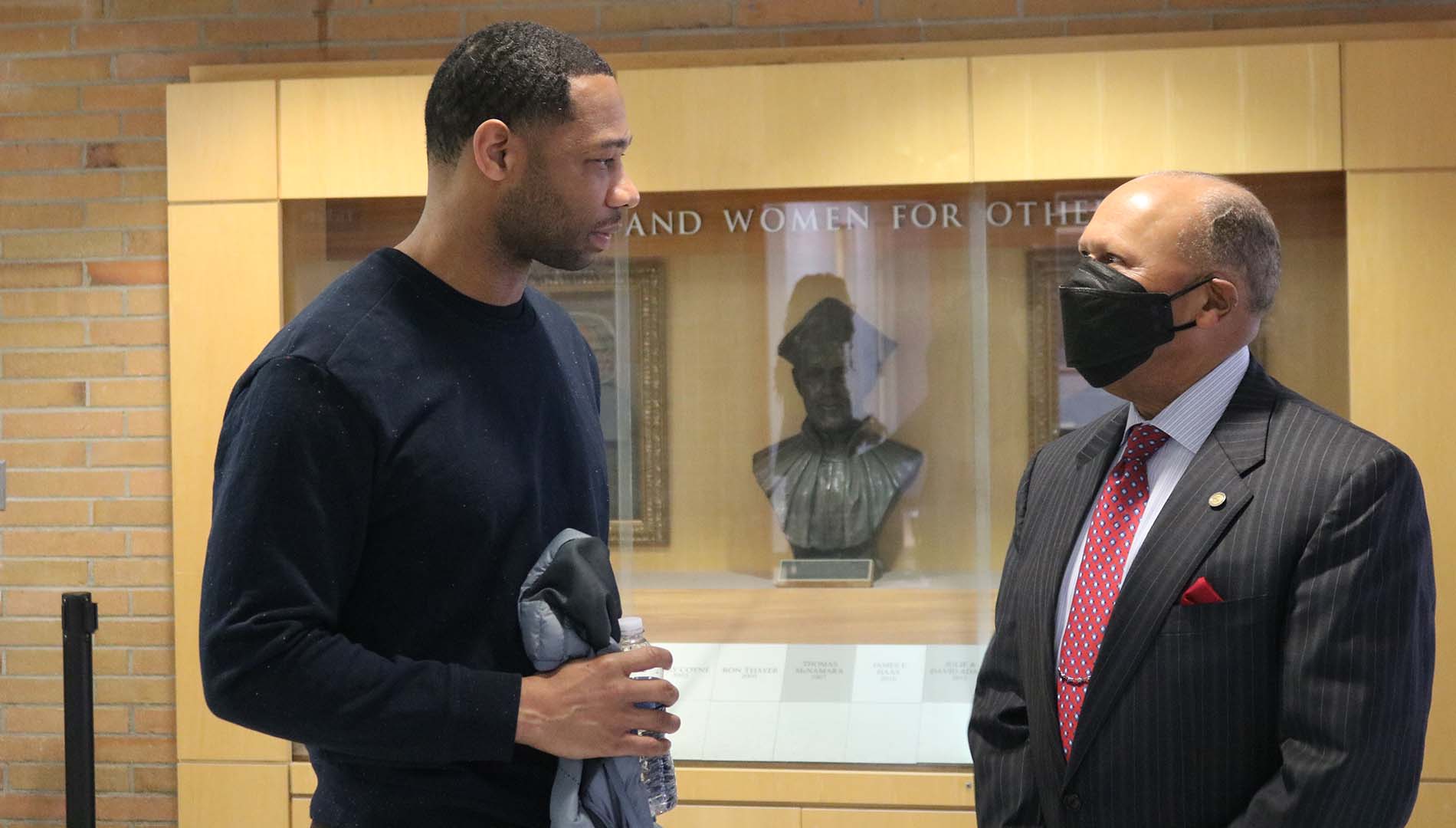 Willie Green '03 talks to Detroit Mercy President Antoine M. Garibaldi at Calihan Hall before the Pelicans played the Pistons.