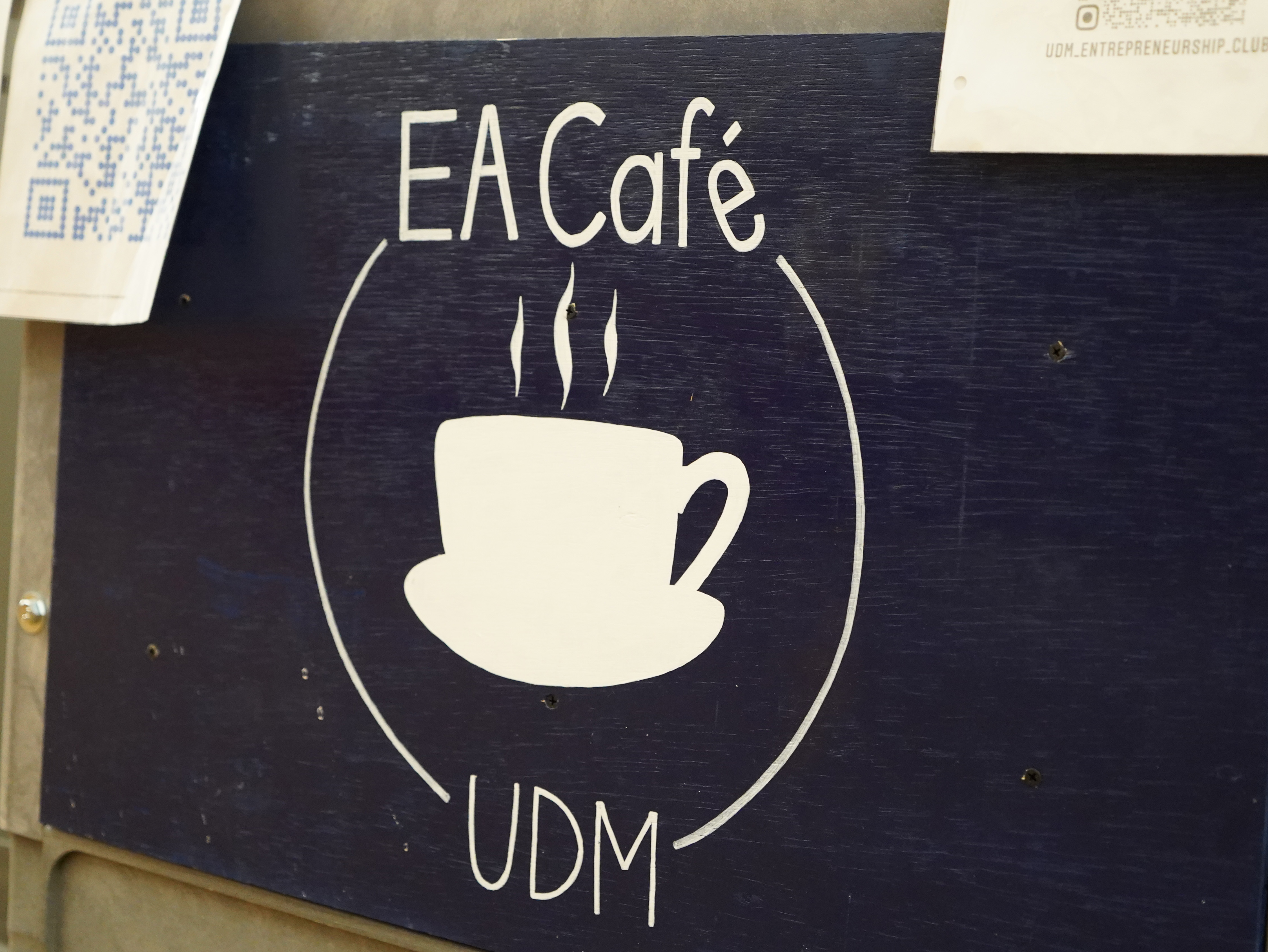 The sign for the EA Cafe at UDM hangs on a coffee cart.