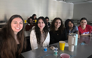 Commuter Student Association students sit together in a classroom as they watch a movie.