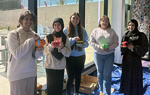 Members of Commuter Student Association hold their decorated pumpkins that were made during an event the organization hosted.