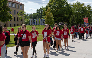 Freshmen walk down Kassab Mall past the TITANS sign during First-Year Convocation.