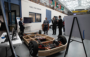 U.S. Sen. Peters and National Cyber Director Harry Coker Jr. look at a vehicle during a visit to UDM's College of Engineering & Science.