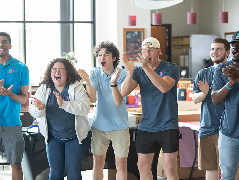 Six students cheer inside of the Student Fitness Center.