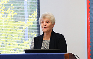 Judy Mouch speaks at a podium.