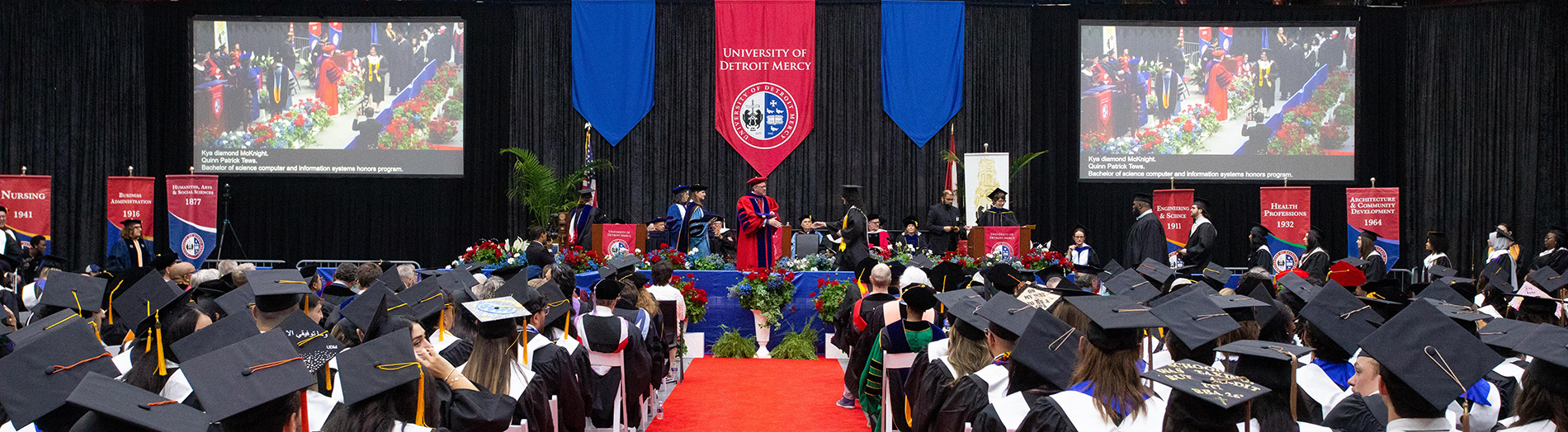 Graduates walk across the stage during Commencement.