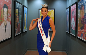 Grace Hanke poses for a photo in front of posters inside the Engineering Building.