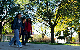A group of students walk on UDM's McNichols Campus.