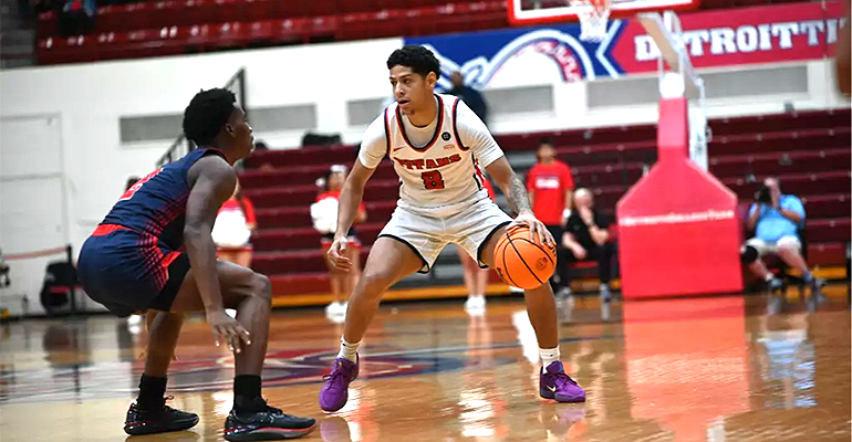 UDM men's basketball player dribbling the ball