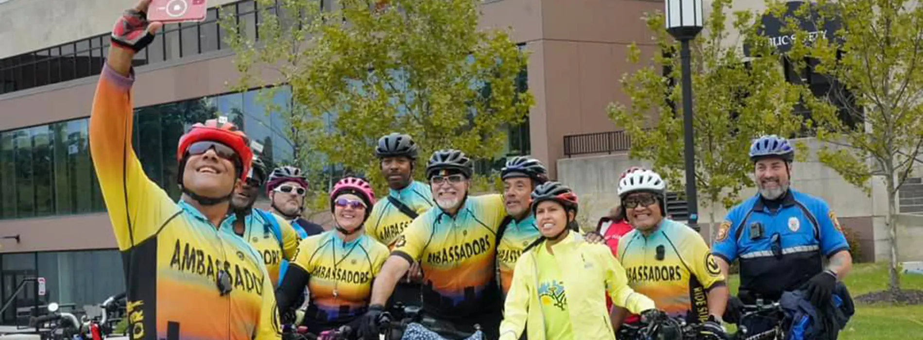 group of alumni waving on bike tour that is hosted at homecoming