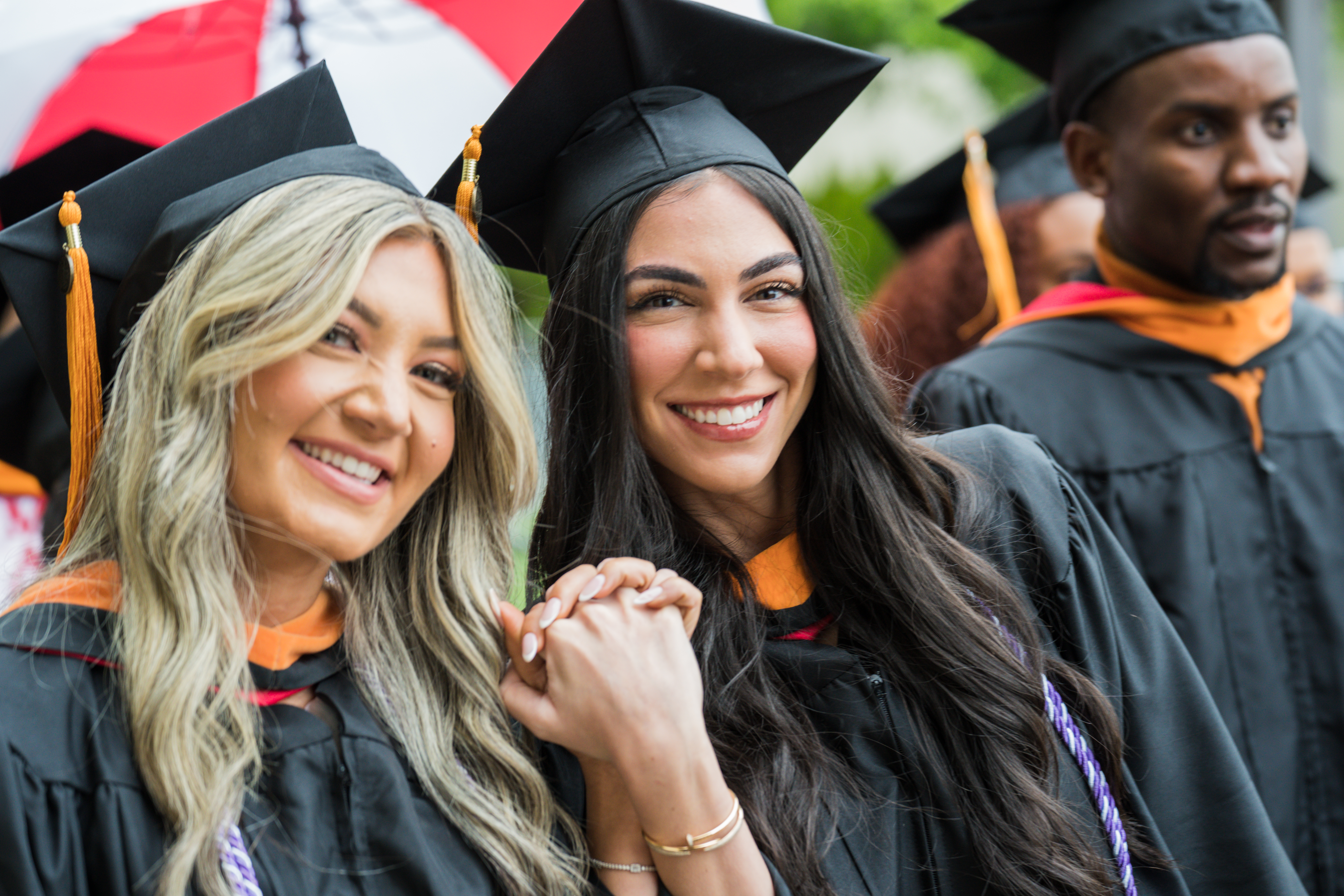 Detroit Mercy student holds up her diploma in excitement.